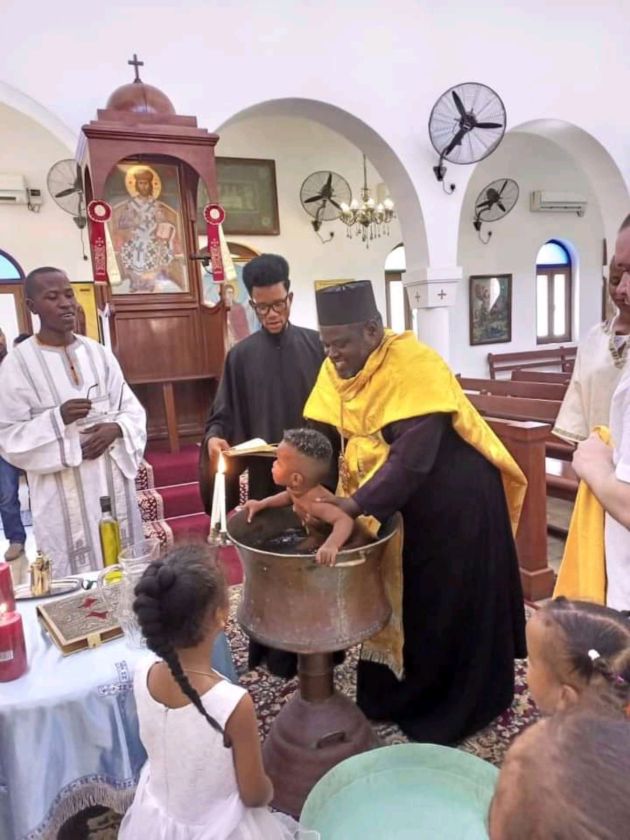 Fr. Cleopas baptizing a child